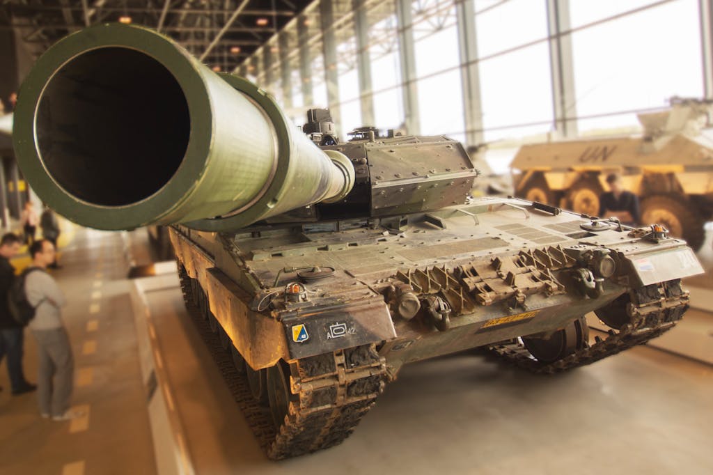 Detailed view of a military tank inside a museum, emphasizing the large barrel and robust design.