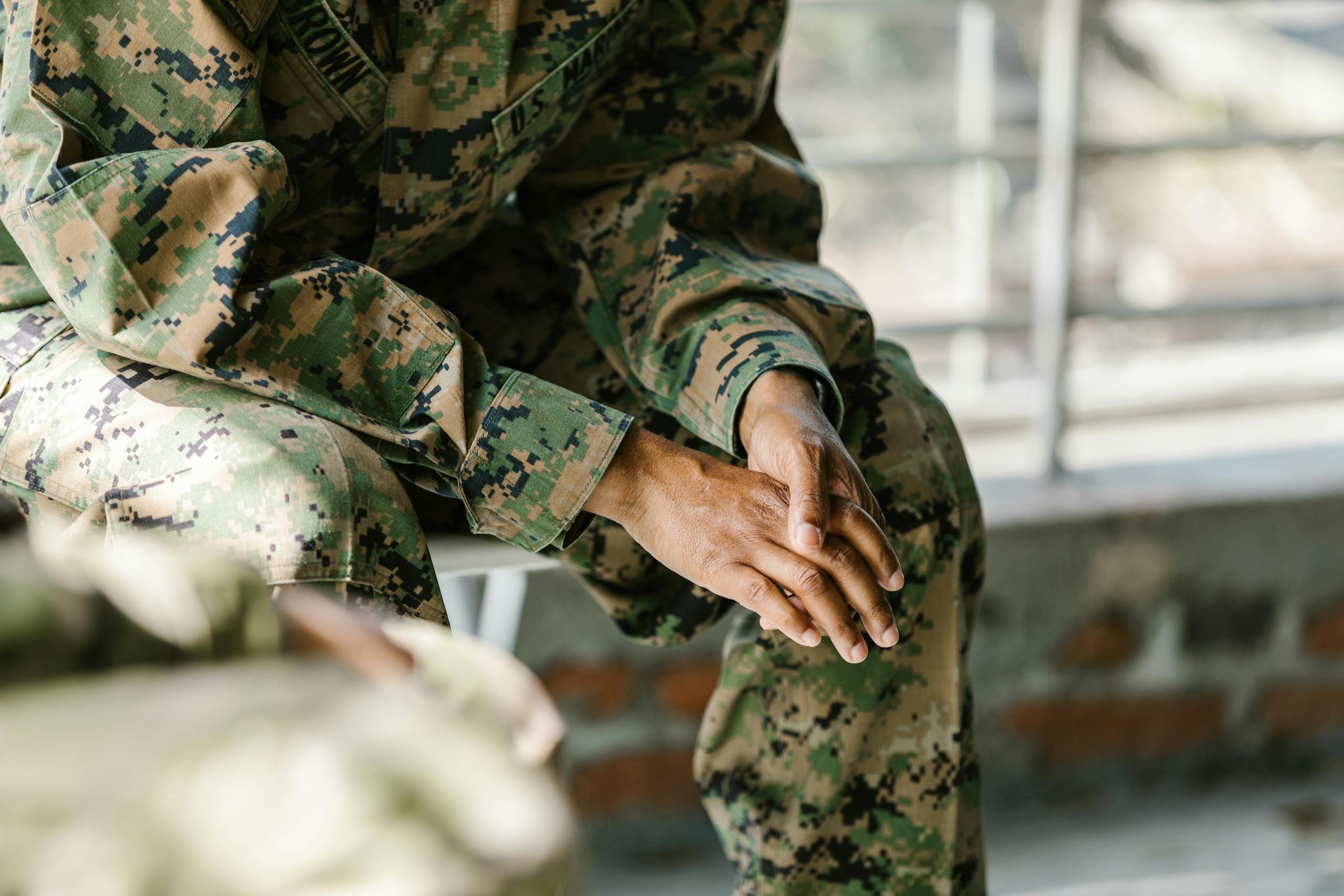 Detail view of a soldier's hands and uniform showing focus and honor.